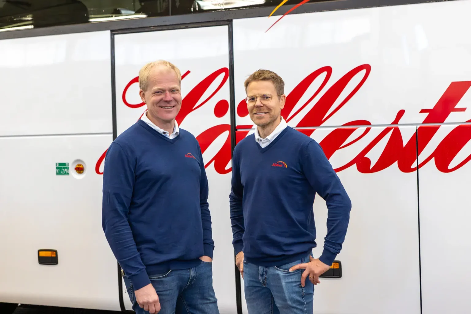 Mats och Per från Hällestagruppen önskar god jul framför buss.