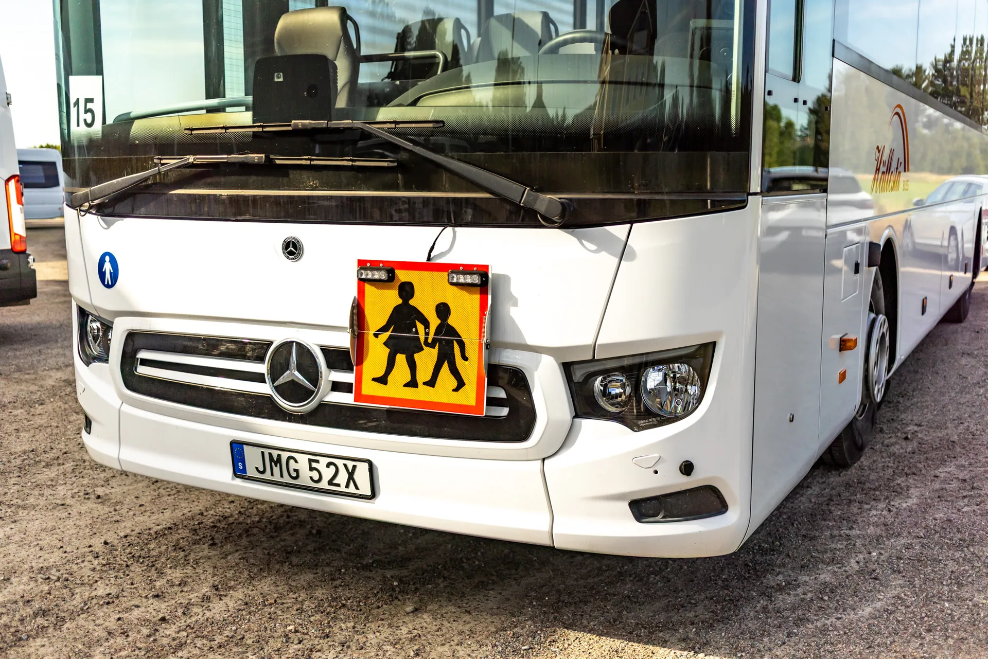 Buss från Hällesta buss med skolskjutsskylt.